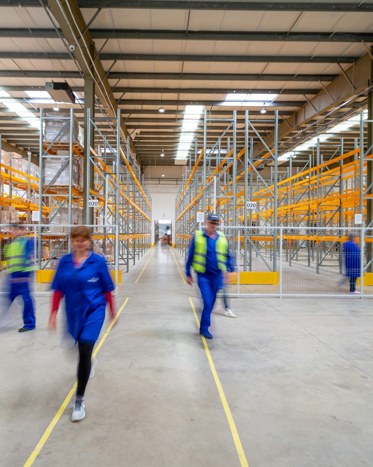 Staff working the aisles of a distribution warehouse.